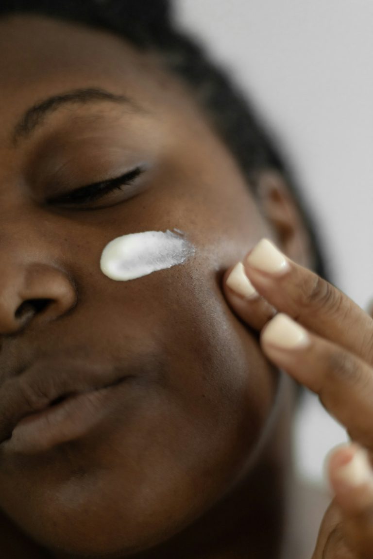 Close-up of a woman applying moisturising cream to her cheek