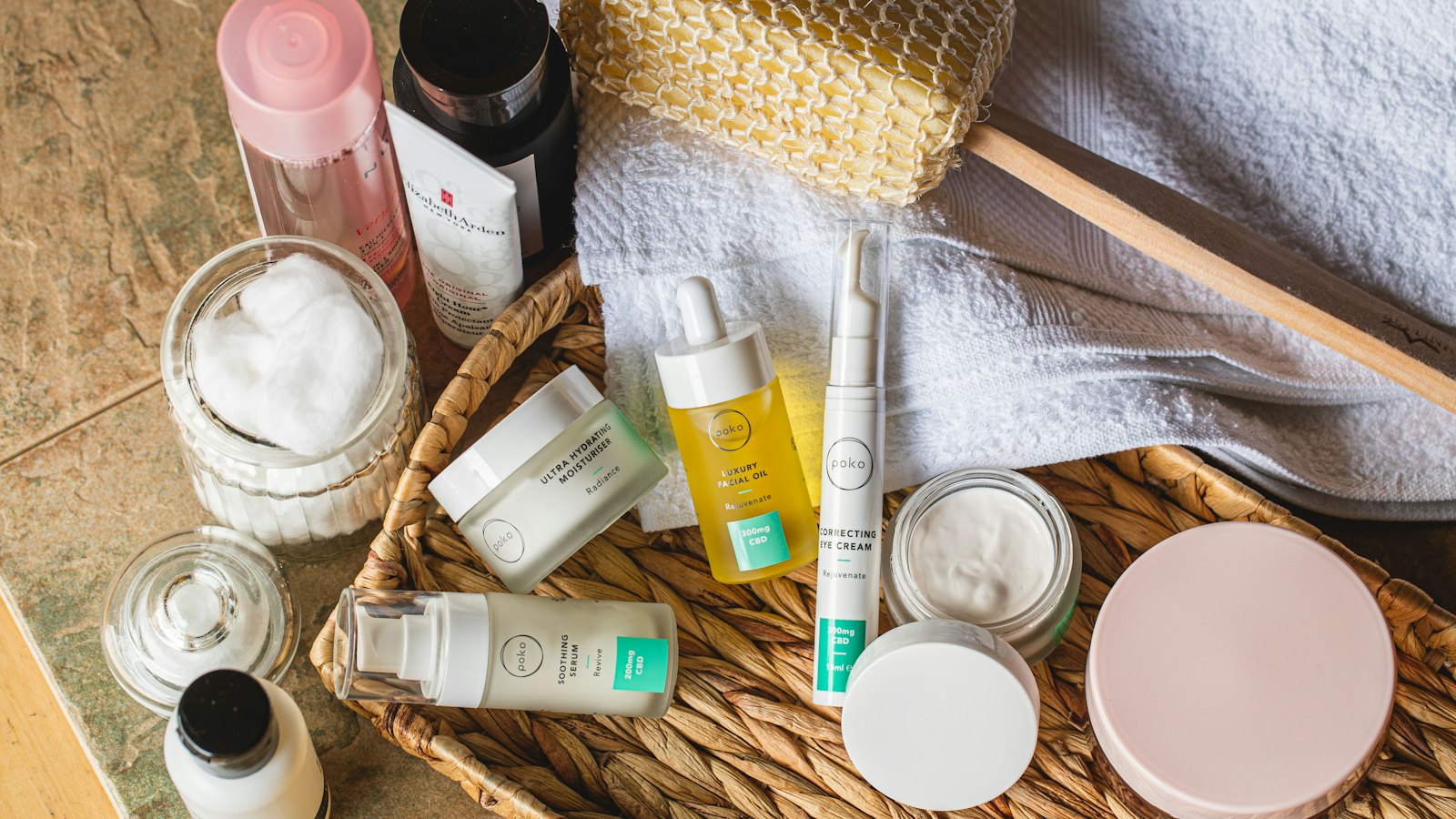 Skincare jars, serums and creams arranged on a wooden tray